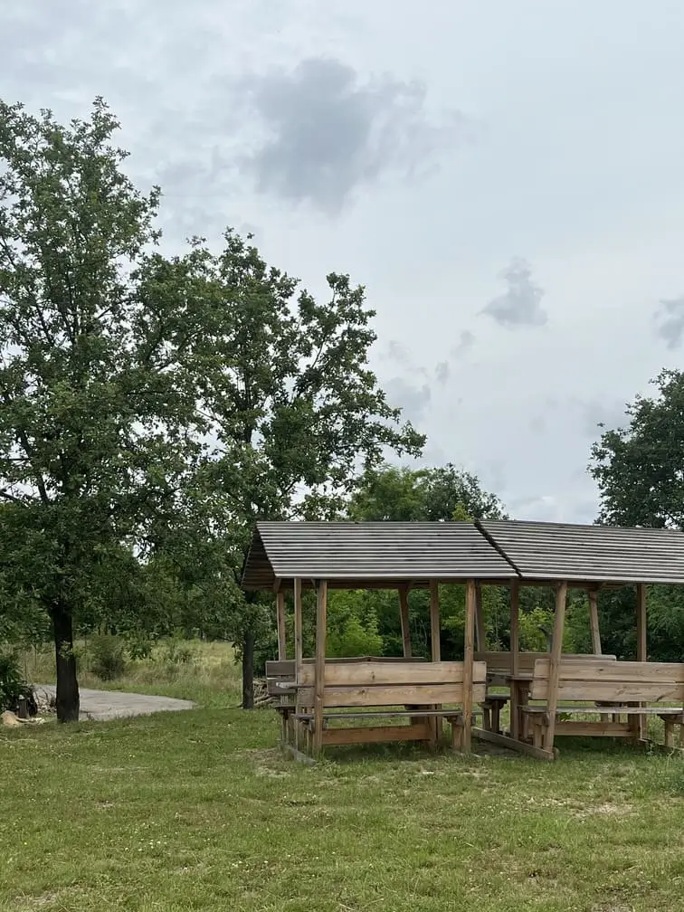 Drewniana altana ze stołami i ławkami na terenie kempingu Gadabout Camp.