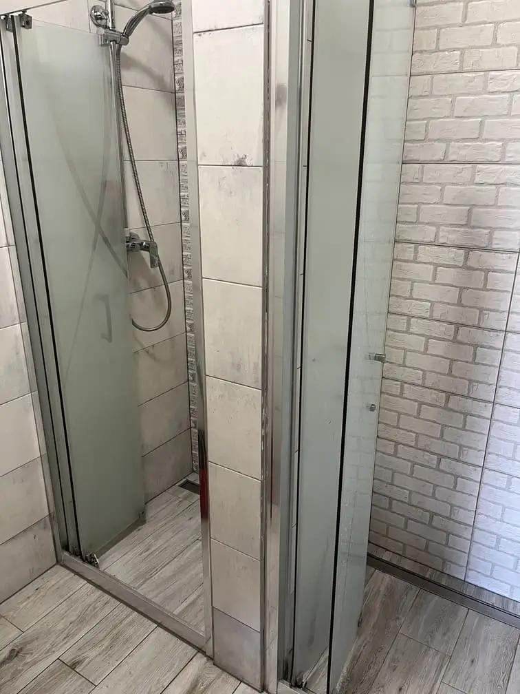 Prysznic w hostelu Gadabout Camp z przeszkleniami i deszczownicą.