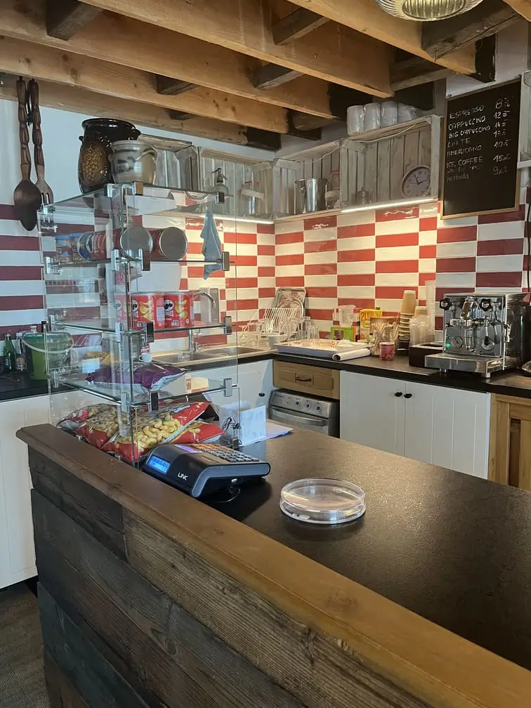 Lada w kawiarni Gadabout Camp z kasą fiskalną i przekąskami.