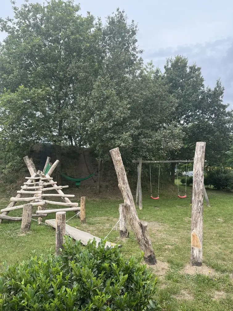 Plac zabaw z drewnianymi konstrukcjami i huśtawkami