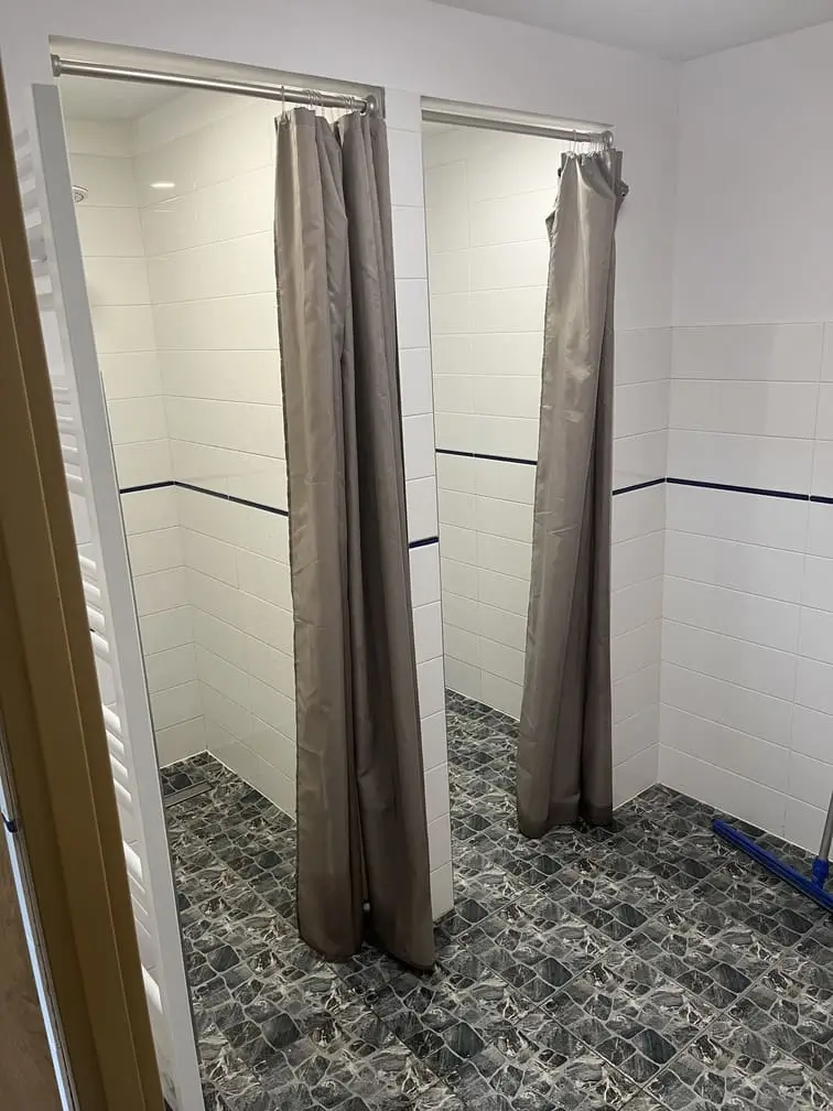 Podwójne kabiny prysznicowe z zasłonami na kempingu