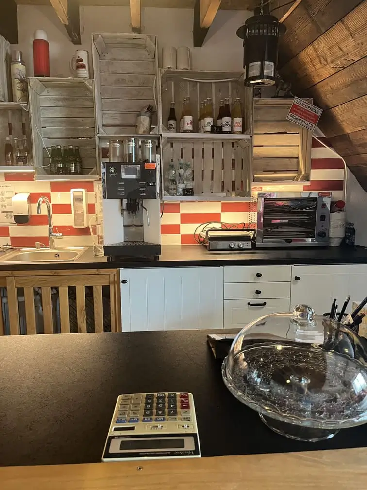Wnętrze kawiarni Gadabout Camp z ekspresami do kawy i ladą sprzedażową.