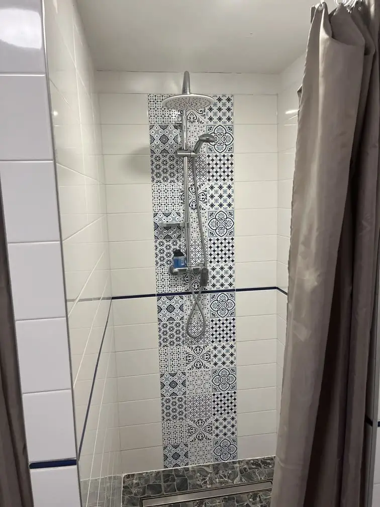 Nowoczesny prysznic z deszczownicą w sanitariatach Gadabout Camp