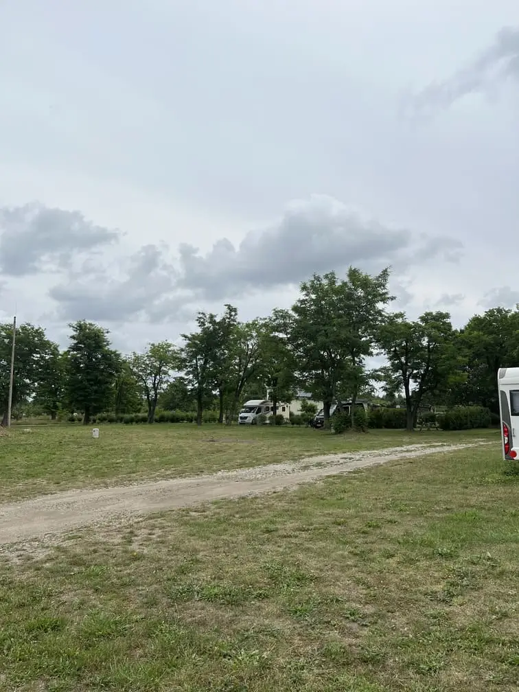 Widok na kemping Gadabout Camp z alejką i kamperem w tle.